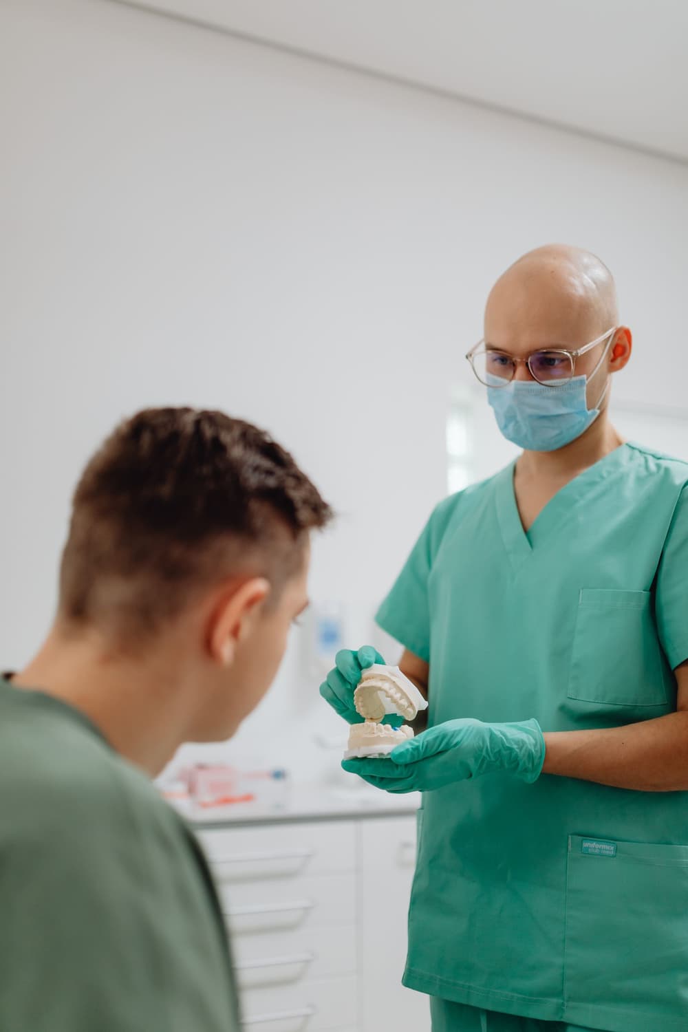 A dentist showing a patient a model of teeth