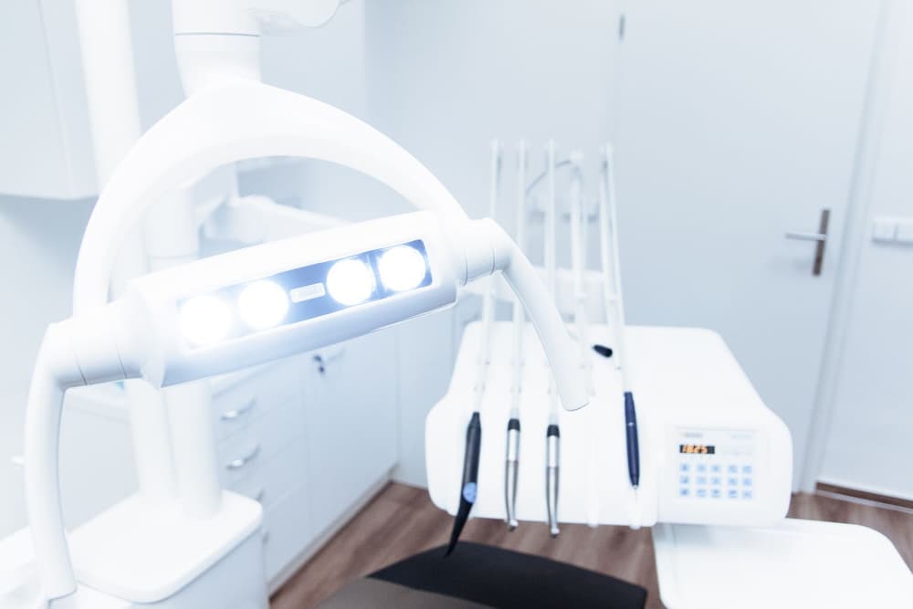 A clean dental room with a chair and overhead light