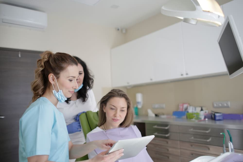 A dental team member reviewing a tablet with a patient