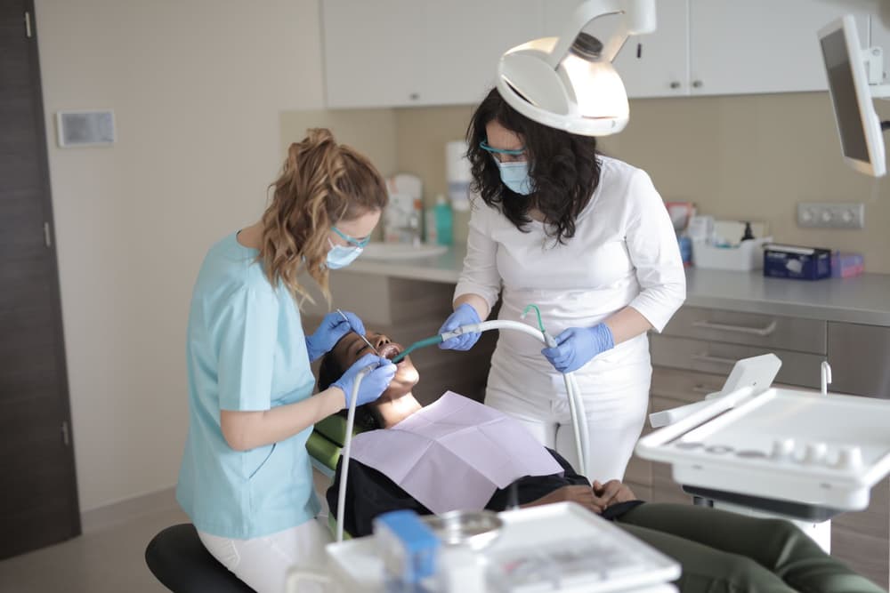 Two dental team members treating a patient